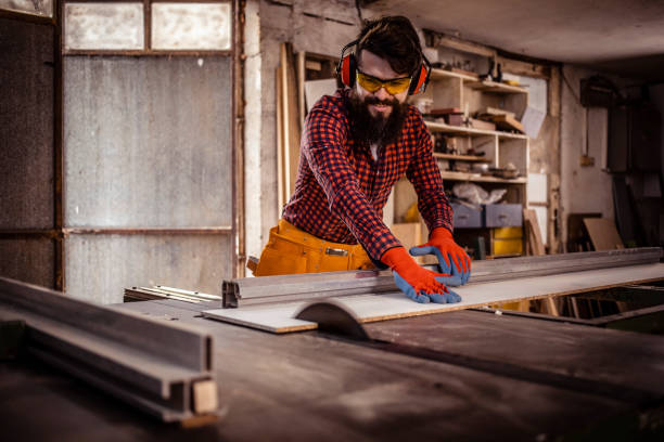istock Young man at carpentry cutting wood with a circular saw 1311298296