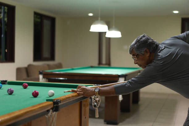 istock Senior man playing billiards at night 1311298344