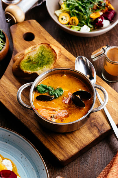 zuppa di crema di pesce con gamberi decorati con foglie tropicali. - tom tom yum meal soup foto e immagini stock