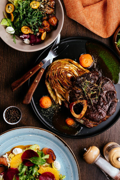 istock Grilled Steak on slate serving platter with vegetables herbs and 1311298512