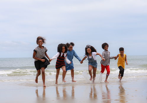 Group of African kid playing joyful on the beach together after unlockdown beach after covid-19 crisis
