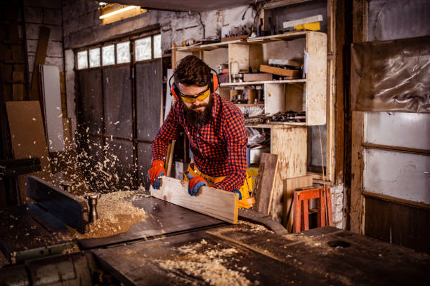 istock Young man at carpentry cutting wood with a circular saw 1311299415