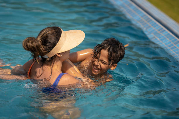 istock Mother and son having fun in the pool 1311299730