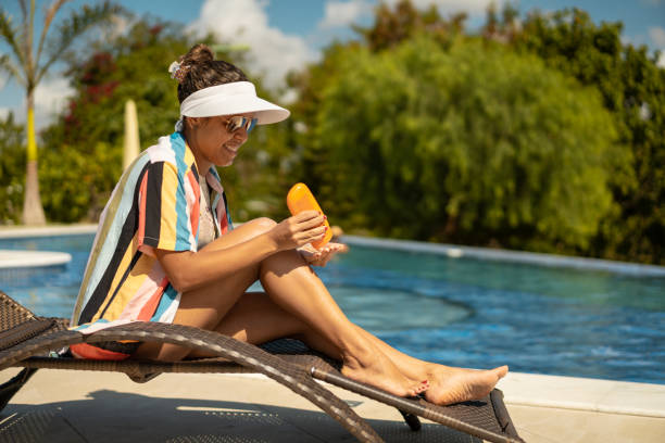 donna che prende il sole a bordo piscina - sun protection foto e immagini stock