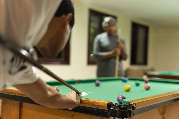 istock Men playing billiard at the gaming house 1311299817