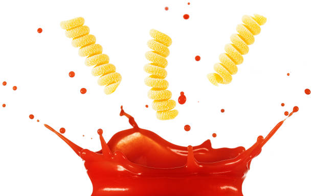 Fusilli pasta above splashing tomato sauce