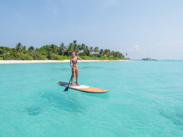 istock Young woman on paddle-board in tropical water 1311306442