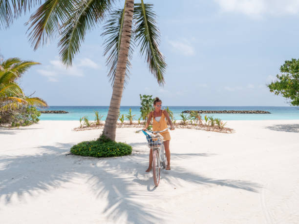 istock young woman with bicycle on the beach 1311306548