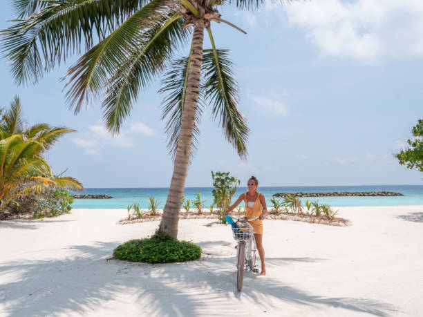 istock An attractive young woman riding her bicycle on the beach 1311306773