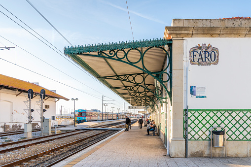 Faro, Portugal - March 24, 2021: A few commuters waiting on train station in Faro, Algarve, Portugal