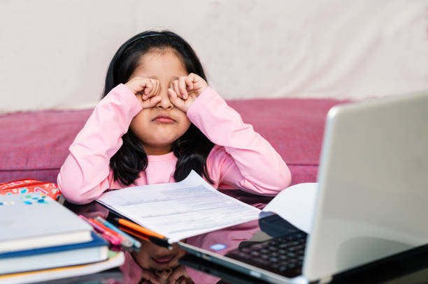 uma menina esfregando os olhos enquanto aulas online no laptop - indian girls audio - fotografias e filmes do acervo