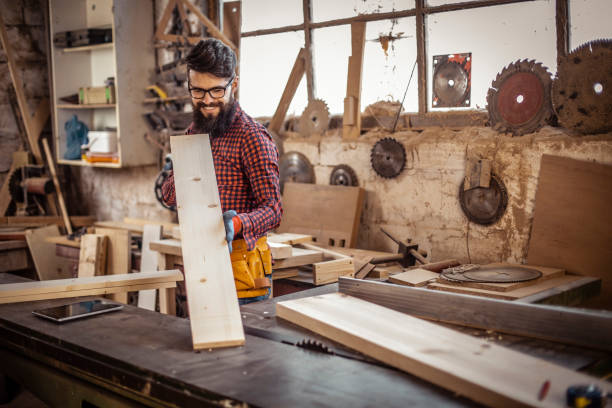 istock Young man at carpentry checking curvature of a plank 1311311896