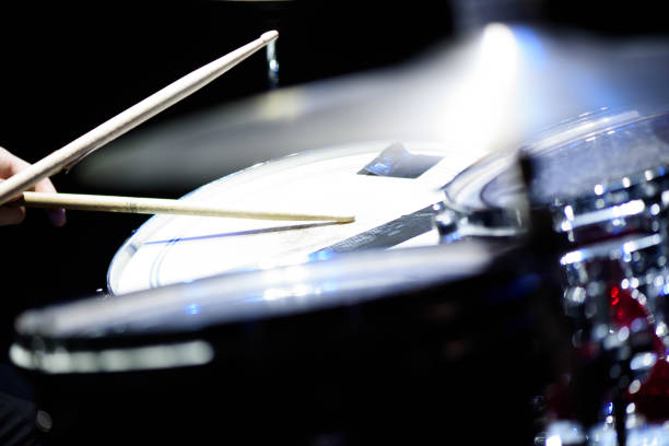 istock man plays musical percussion instrument with sticks closeup on a black background, a musical concept with the working drum, beautiful lighting on stage 1311313022