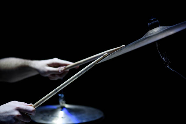 istock man plays musical percussion instrument with sticks closeup on a black background, a musical concept with the working drum, beautiful lighting on stage 1311313049