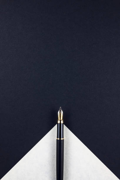 black fountain pen with nib on top of ivory paper triangle on dark cardboard - fountain pen business pen writing imagens e fotografias de stock