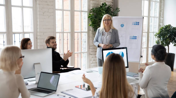 istock Diverse employees applaud greeting female coach at meeting 1311315522