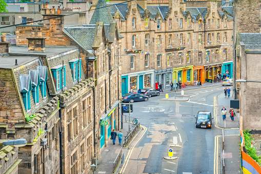 Street with old stone facades and colorful stores in Old Town Edinburgh, Scotland