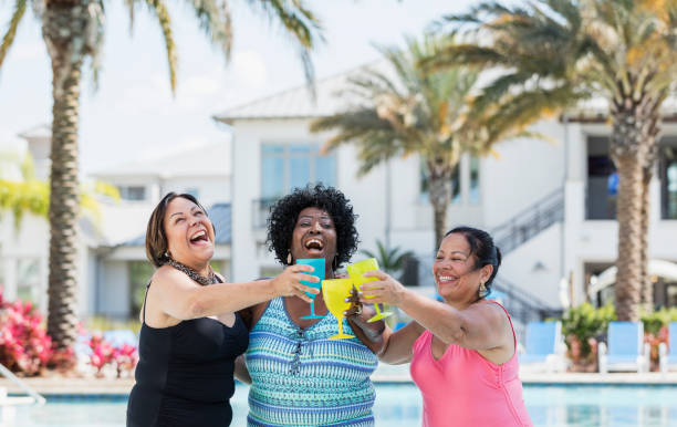 istock Three senior women on vacation, in pool with drinks 1311316465