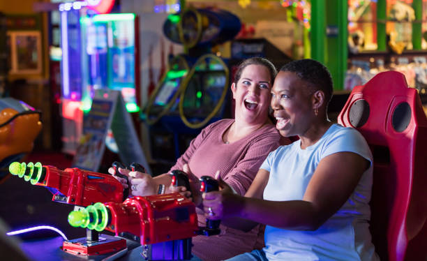 istock Two women playing amusement arcade game 1311317250