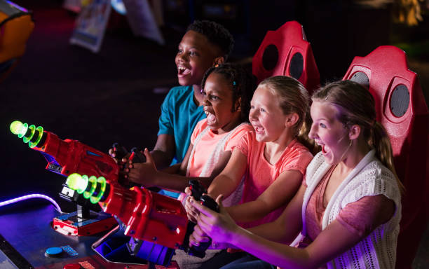 quatro crianças jogando jogo de fliperama de diversão - amusement arcade - fotografias e filmes do acervo