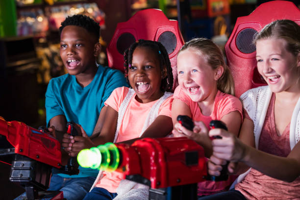 Four children playing amusement arcade game