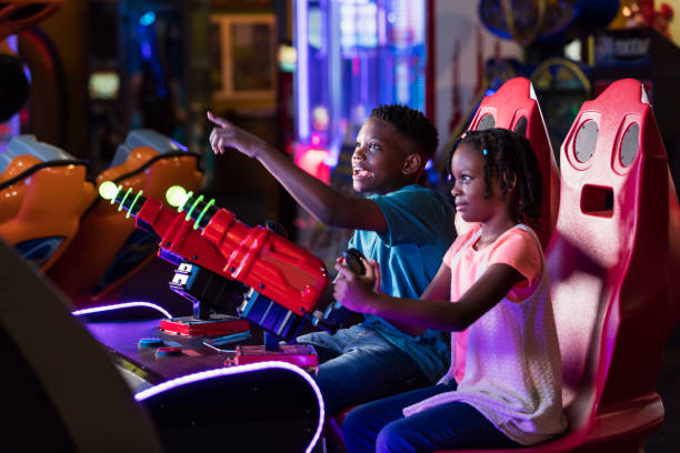 istock Boy and sister playing amusement arcade game 1311317394