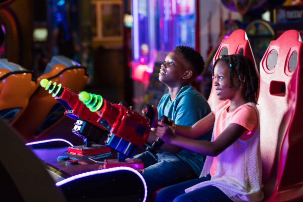 menino e irmã jogando jogo de fliperama de diversão - amusement arcade - fotografias e filmes do acervo