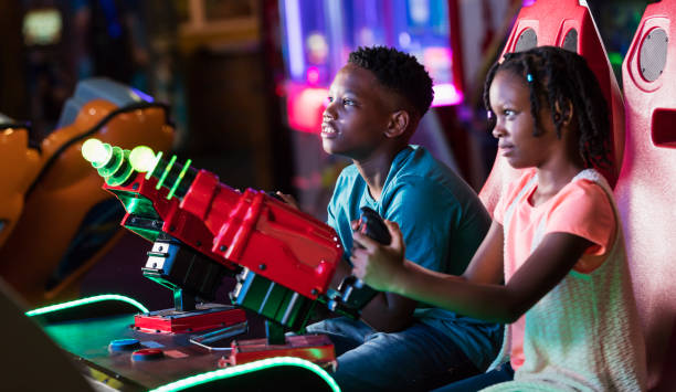 istock Boy and sister playing amusement arcade game 1311317437