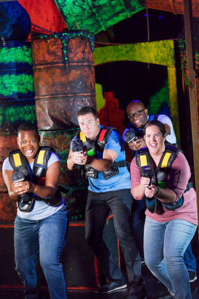 istock Four multi-ethnic adults playing laser tag 1311317460