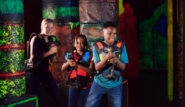 drei kinder spielen laser-tag - fangen stock-fotos und bilder