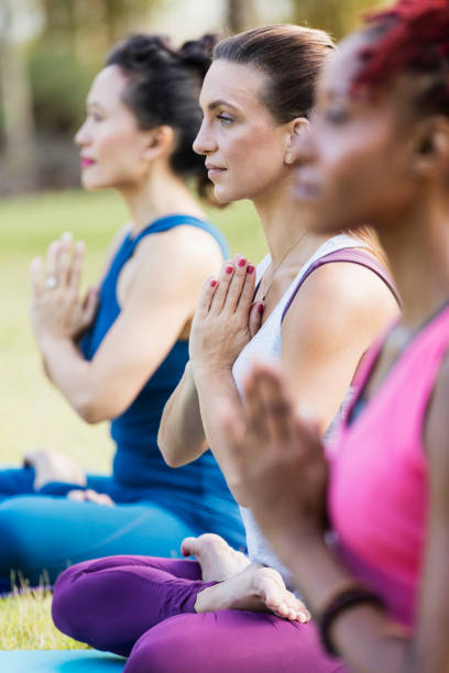 istock Women outdoors doing yoga, lotus pose with prayer hands 1311318405