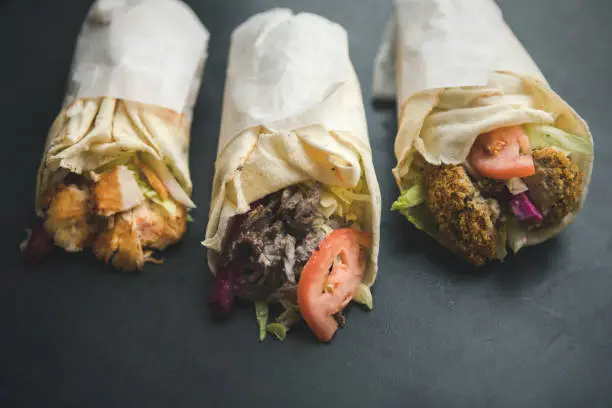 Middle eastern style street food: grilled chicken, shawarma and falafel pita wrap sandwich