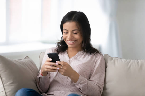 istock Happy biracial woman relax on sofa using smartphone 1311319762