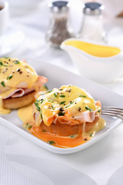 istock Breakfast. Best Eggs Benedict - fried English bun, ham, poached eggs and delicious Hollandaise   butter sauce 1311321724
