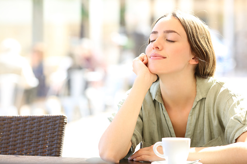 Woman relaxing with closed eyes in a coffee shop