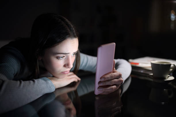 Sad female checking phone content in the night at home Sad female checking phone content in the night at home waiting telephone on the phone frustration stock pictures, royalty-free photos & images