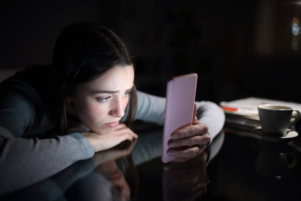 smutna kobieta sprawdzająca zawartość telefonu w nocy w domu - social media instagram twitter telephone zdjęcia i obrazy z banku zdjęć