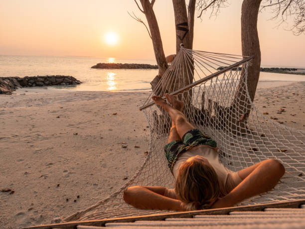 istock Man relaxing on hammock at sunrise 1311325216