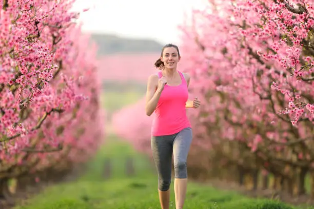 Photo of Jogger running in a pink flowers field