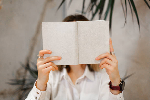 istock the girl hid behind an open book with an empty cover 1311328229