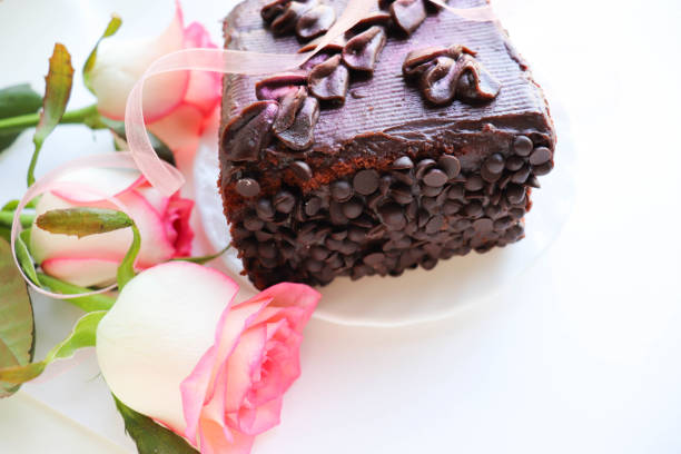 Red cake with rose, chocolate flower, on dark background. Free space for text. Selective focus