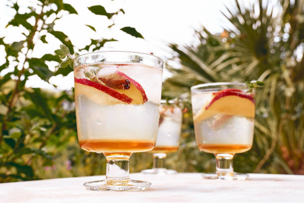 istock Fresh and healthy cocktail or mocktail with apple, ice, cinnamon and herbs. Refreshing summer drink on nature background 1311331452