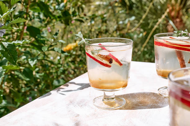 istock Fresh and healthy cocktail or mocktail with apple, ice, cinnamon and herbs. Refreshing summer drink on nature background 1311331533
