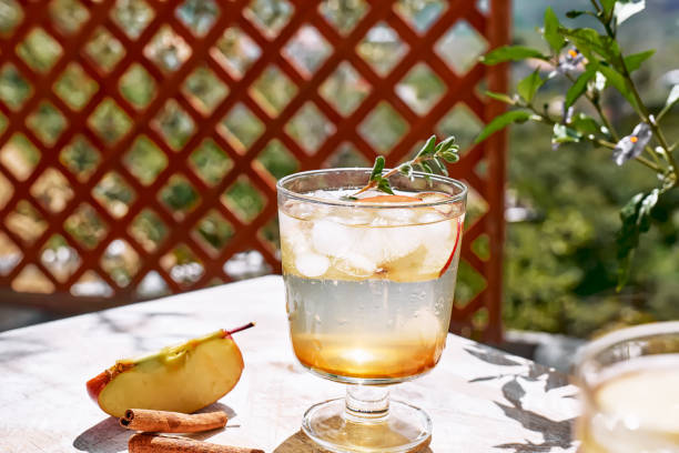 istock Fresh and healthy cocktail or mocktail with apple, ice, cinnamon and herbs. Refreshing summer drink on nature background 1311331612