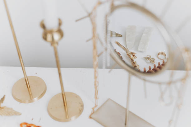 istock Modern golden accessory and hair clips reflected in boho mirror on white table with vintage candles 1311335151