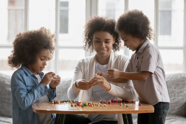 istock Millennial Black mom teaching kids to make craft decoration 1311335780