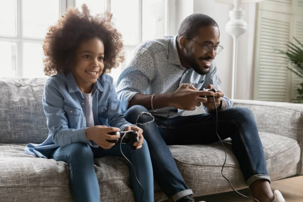 istock Happy Black dad and kid playing online computer video game 1311335789