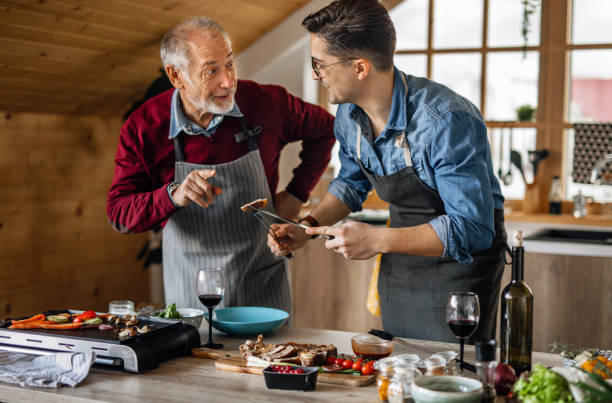 istock Father and son ejoying cooking dinner for friends together 1311336949