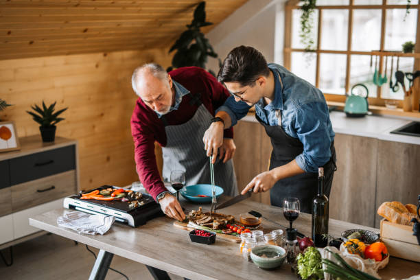 istock Father and son ejoying cooking dinner for friends together 1311336958