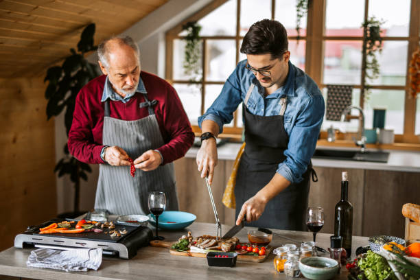 istock Father and son ejoying cooking dinner for friends together 1311337059